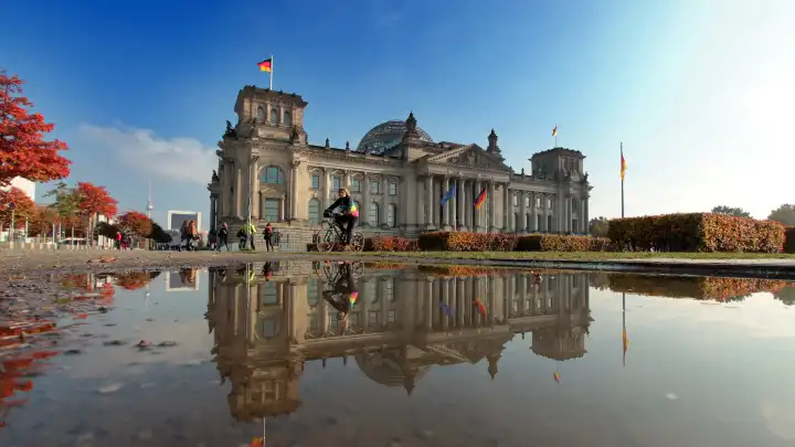 goldener Oktober in Berlin Reichstag spiegelt sich bei schönstem Herbstwetter in einer Wasserpfütze, Deutschland