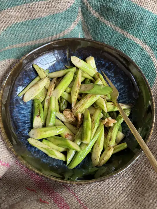 Roasted green asparagus with walnut halves, lunch or snack