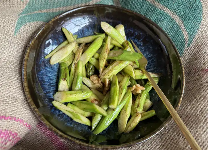 Roasted green asparagus with walnut halves, lunch or snack