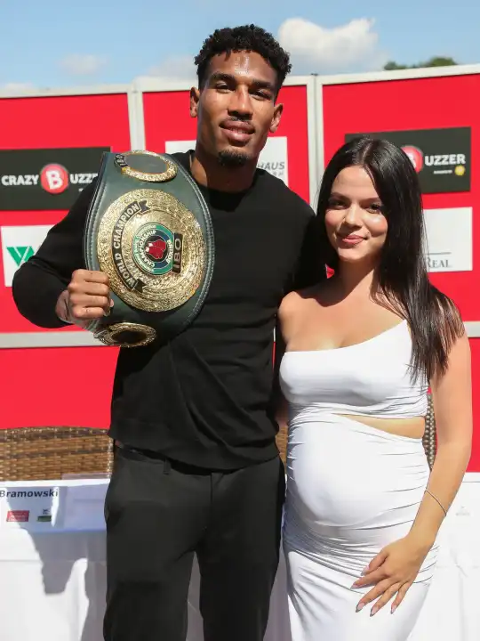 IBO-Weltmeister Super-Mittelgewicht Osleys Iglesias Estrada mit Ehefrau Lucy und WM-Gürtel bei der Pressekonferenz am 23. August 2023 in Magdeburg