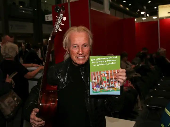 Schlagersänger und Kinderbuchautor Christian Anders mit Gitarre und Kinderbuch auf der Leipziger Buchmesse 2024 am 21.03.2024