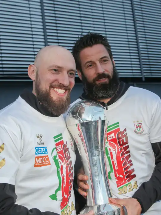 Assistant coach Yves Grafenhorst and head coach Bennet Wiegert (both SC Magdeburg) with trophy at the reception of the current DHB Cup winner 2024 SC Magdeburg on 15.04.2024 at the GETEC Arena Magdeburg