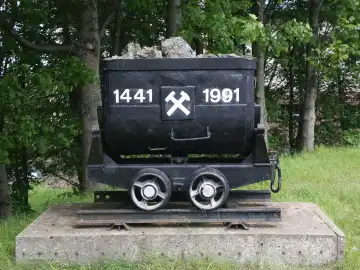 View of a wagon with rock in front of the Arno Lippmann shaft in the Europark in Altenberg in summer 2024
