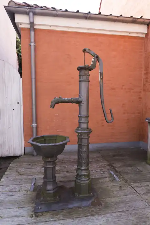 Altertümliche Wasserpumpe mit Schwengel und Waschbecken in Nykøbing