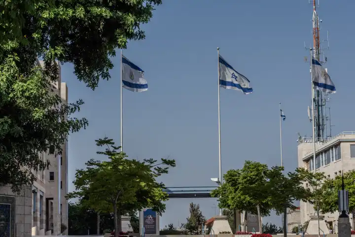 Flagpoles with waving Israeli flags in front of the City Hall in Jerusalem, Israel.