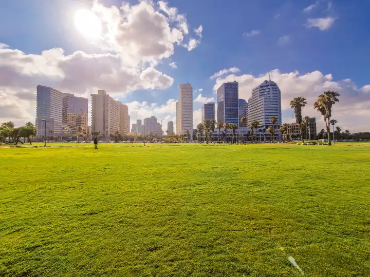Blick auf die Skyline von Tel Aviv in Israel. Hochhäuser vom Charles Clore Park aus bestrachtet. Sonnenschein mit einzelnen Wolken vor blauem Himmel