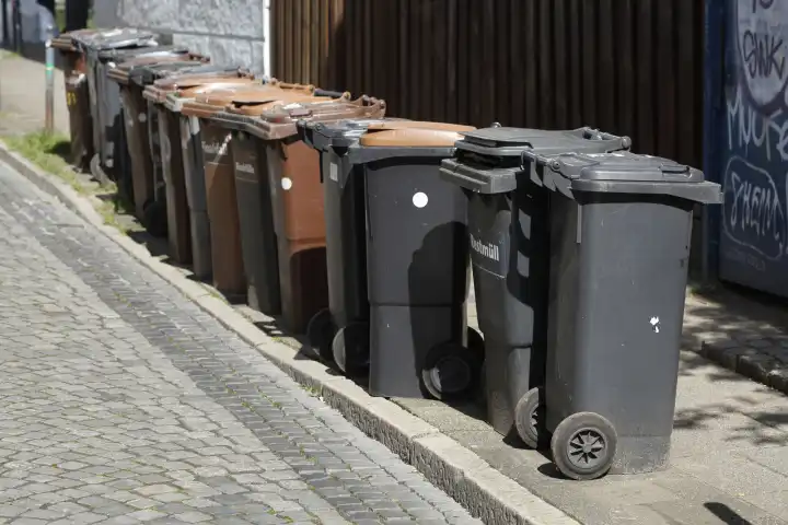 Mülltonnen in einer Reihe auf der Straße stehend, Deutschland
