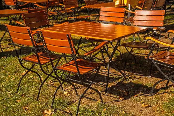 empty German beer garden with wooden furniture in late summer sun