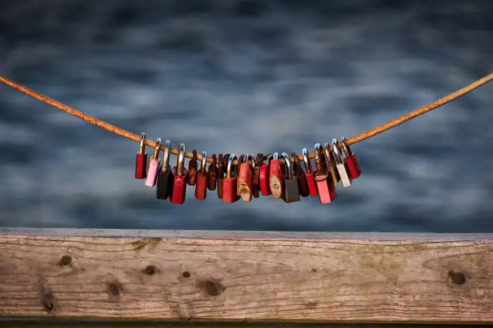 Love locks weathered on a chain on a bridge