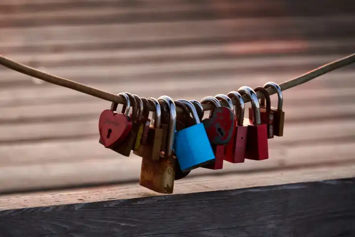Love locks weathered on a chain on a bridge