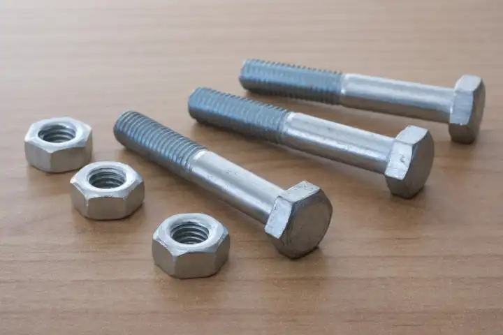 Hexagon head screws with shank and nuts on wooden background, steel screw, machine screw, wrench screw
