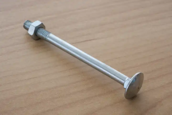 Truss-head bolt with hexagon nut on wooden background, wrench bolts