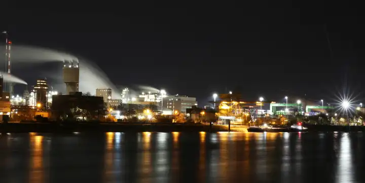 Nachtaufnahme von der BASF in Ludwigshafen mit dem Rhein im Vordergrund