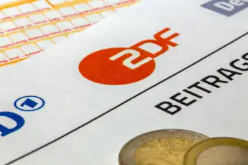 Symbolic image of broadcasting contribution, contribution service: Close-up of a letterhead with ARD logo and ZDF logo and a remittance slip and money coins.