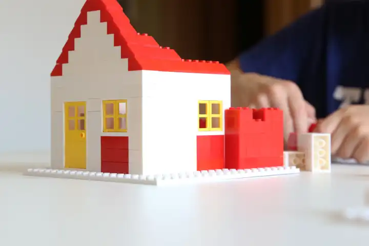 Symbolic image: Boy builds a house with building blocks (Model released)