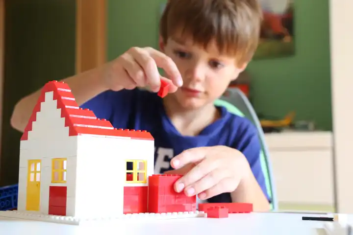 Symbolic image: Boy builds a house with building blocks (Model released)