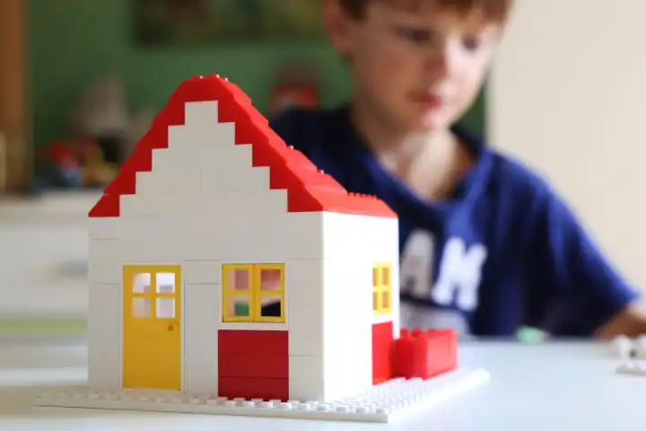 Symbolbild: Junge baut mit Bausteinen ein Haus (Model released)