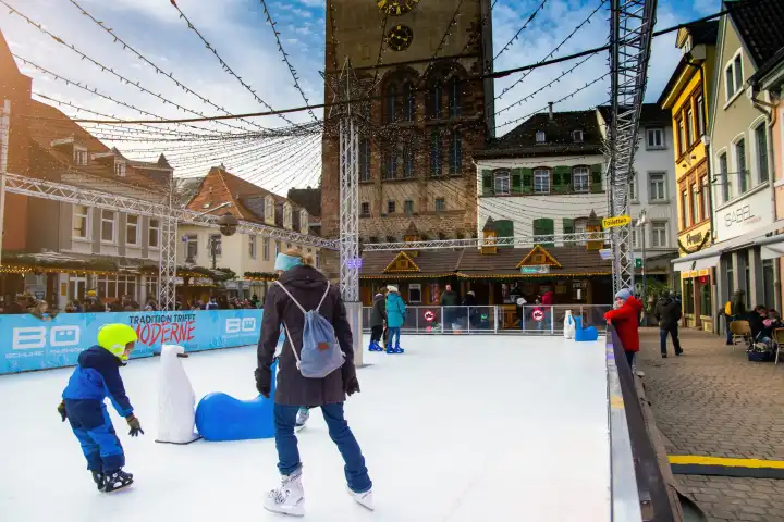 Schlittschuhlaufen auf dem Weihnachtsmarkt in Speyer, Rheinland-Pfalz: Im Schatten des bekannten Altpörtels steht in diesem Jahr eine Kunsteisbahn