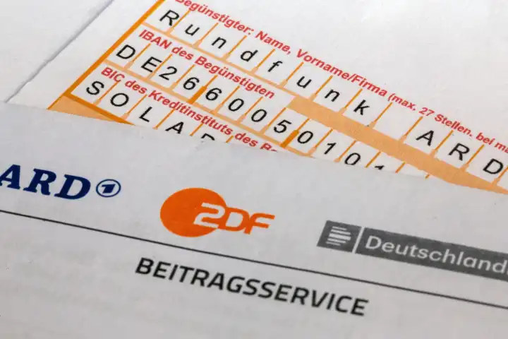 Symbolbild Rundfunkbeitrag: Nahaufnahme von einem Briefbogen mit ARD- und ZDF-Logo und einem Überweisungsträger