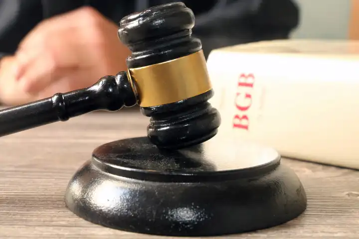 Trial symbol image: close-up of a judge's gavel and BGB (German Civil Code).