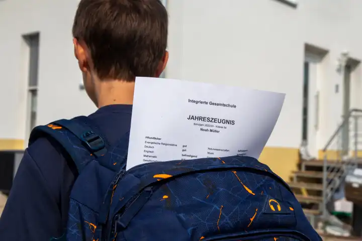 Symbolbild Zeugnisvergabe: Schüler einer integrierten Gesamtschule auf dem Nachhauseweg mit seinem Jahreszeugnis (model released)