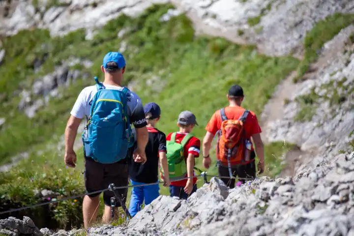 Wandern in den Allgäuer Alpen: Gruppe mit Kindern beim Abstieg vom Gipfel der Kanzelwand (Kleinwalsertal, Österreich)