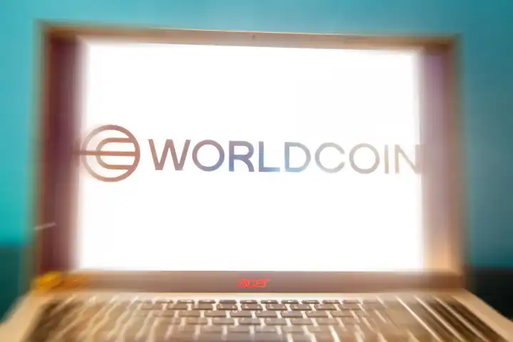 Logo der neuen Kryptowährung Worldcoin auf einem Laptop. Wer an World Coin teilnehmen möchte muss sich mit seinen biometrischen Daten registrieren lassen (Symbolbild)