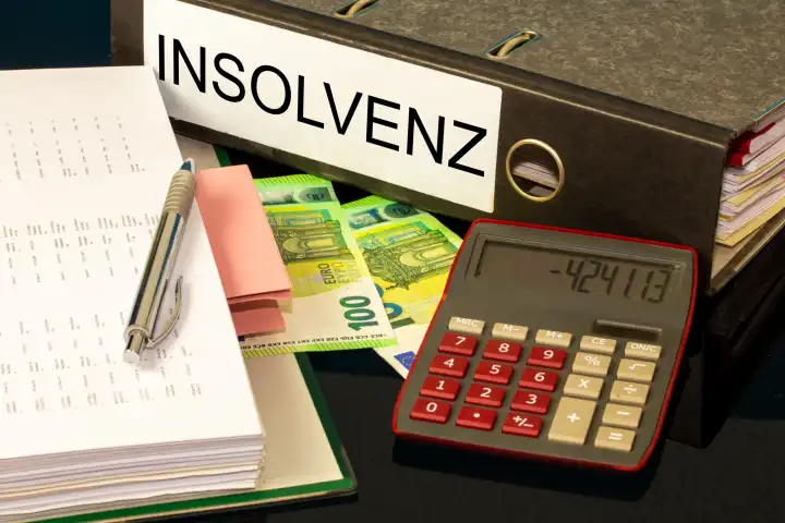 Symbolbild Insolvenz: Ordner, Taschenrechner und Euro-Banknoten