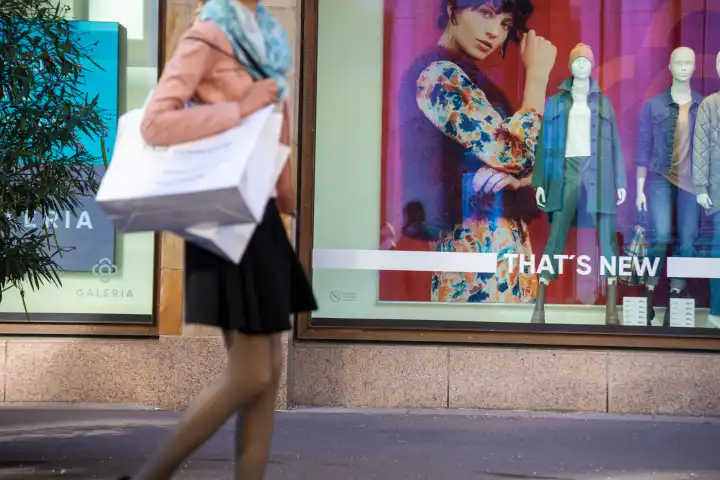 Symbolbild Einkaufen: Junge Frau beim Einkaufen läuft an der Galeria Kaufhof in Karlsruhe vorbei (Model released)