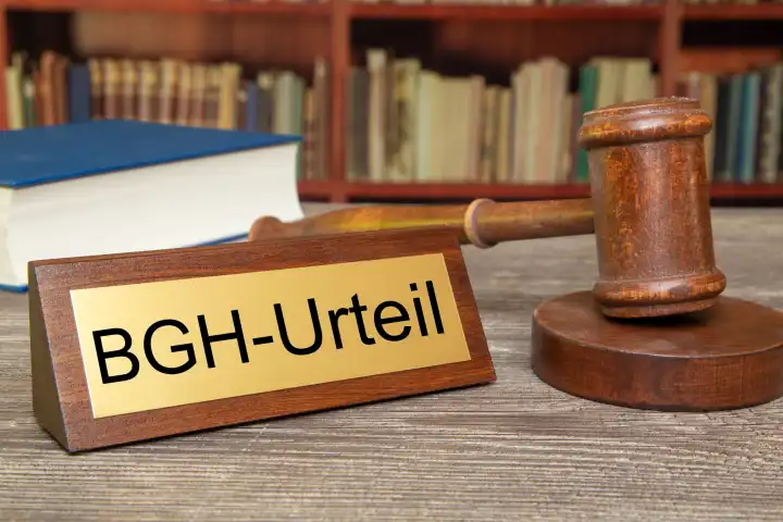 Symbolbild BGH (Bundesgerichtshof): Richterhammer neben einem Messingsschild mit der Aufschrift BGH-URTEIL (Composing)
