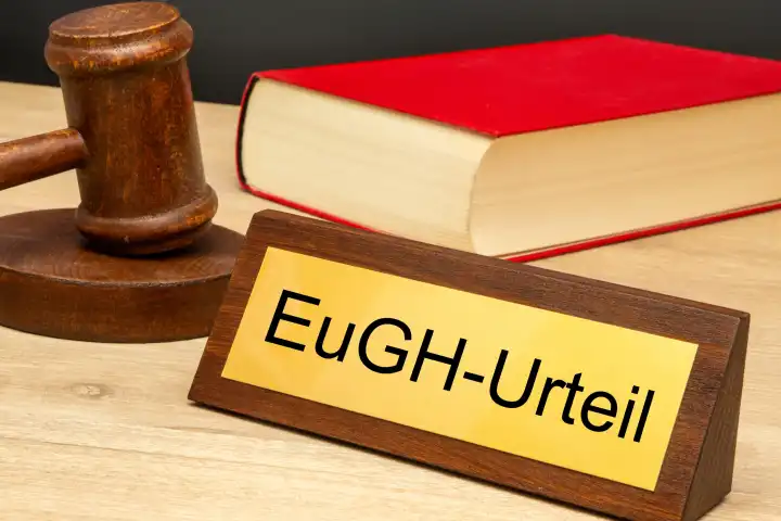 Symbolbild EuGH (Europäischer Gerichtshof): Richterhammer neben einem Messingsschild mit der Aufschrift EuGH-URTEIL (Composing)