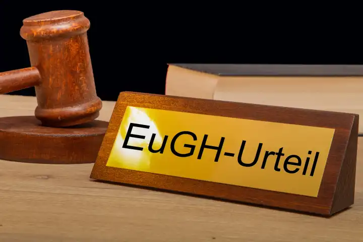 Symbolbild EuGH (Europäischer Gerichtshof): Richterhammer neben einem Messingsschild mit der Aufschrift EuGH-URTEIL (Composing)