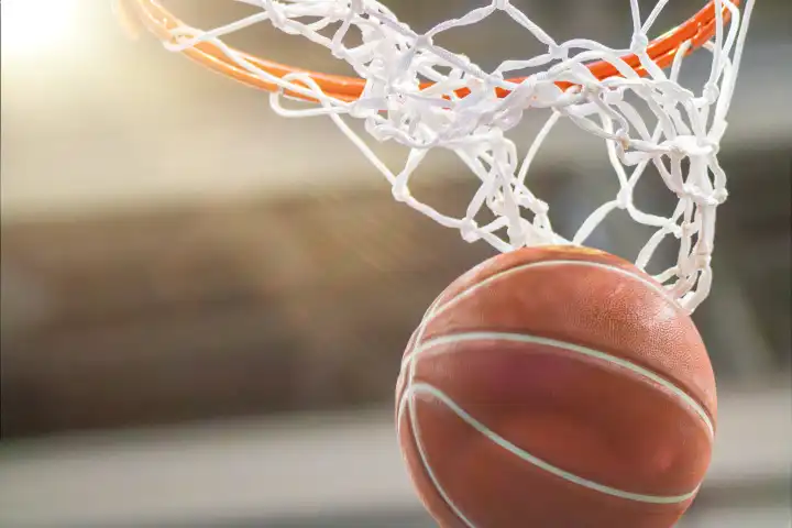 Close-up of a basketball landing in the hoop