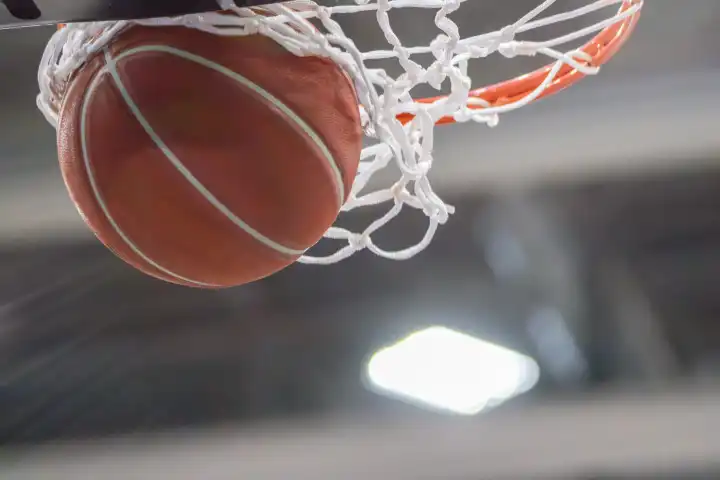 Close-up of a basketball landing in the hoop