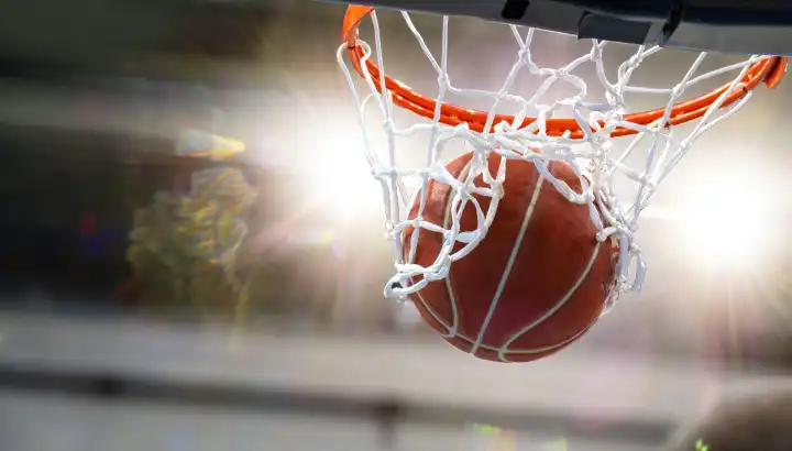 Close-up of a basketball landing in the hoop (with space for text or logo)