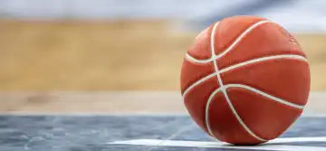Close-up of basketball on the floor of a hall (with free space for text or logo)