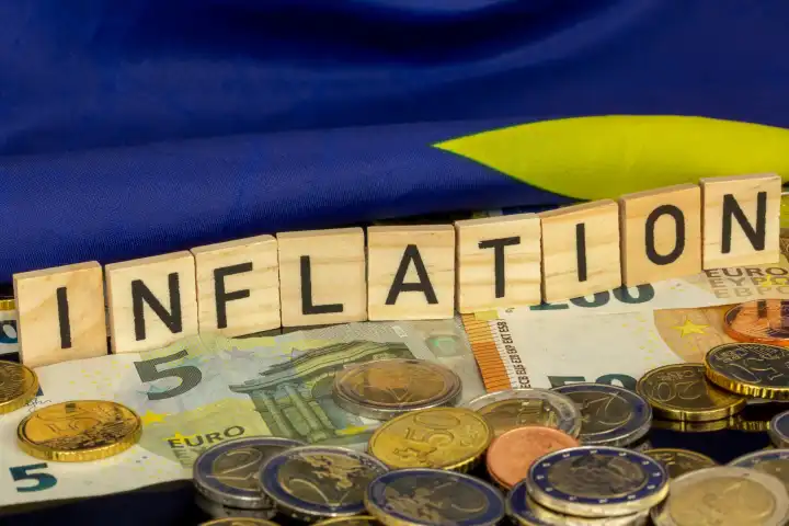 Symbolic image of inflation (in the euro area): The word INFLATION in letter cubes on euro coins and banknotes