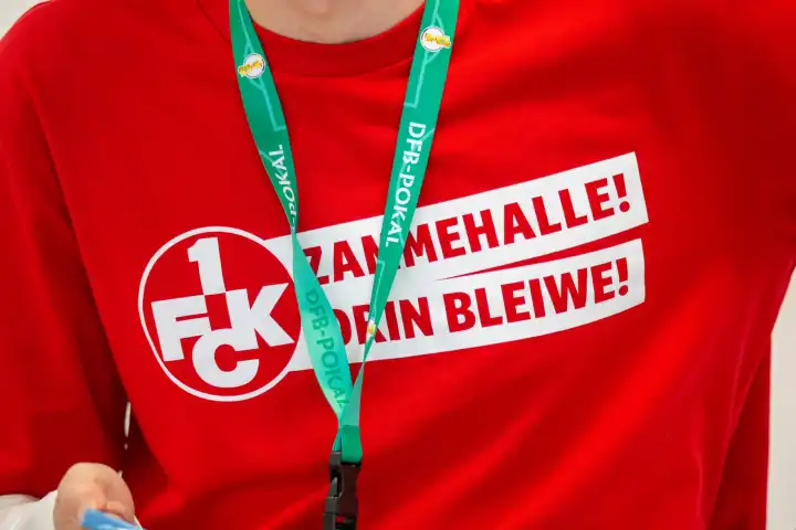 20.04.2024: Große Vorfreude auf das DFB-Pokalfinale in Berlin und gleichzeitig Abstiegskampf in der 2. Bundesliga. Auf einem T-Shirt steht die Losung auf pfälzisch ZAMMEHALLE! DRIN BLEIWE! 