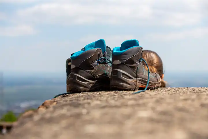 Hiking in the mountains: close-up of hiking boots on the summit (Palatinate Forest with a view of the Rhine plain)