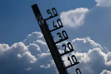 Symbolic image of heat/storm warning: Thermometer in front of building cumulus clouds (Composing)