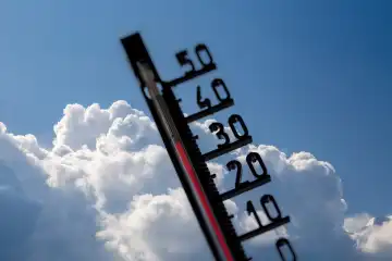 Symbolbild Hitze/Unwetterwarnung: Thermometer vor sich aufbauenden Quellwolken (Composing)