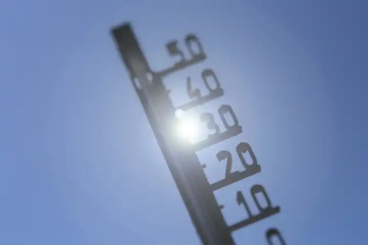 Symbolbild Hitze: Thermometer vor sommerlichem Himmel (Composing)