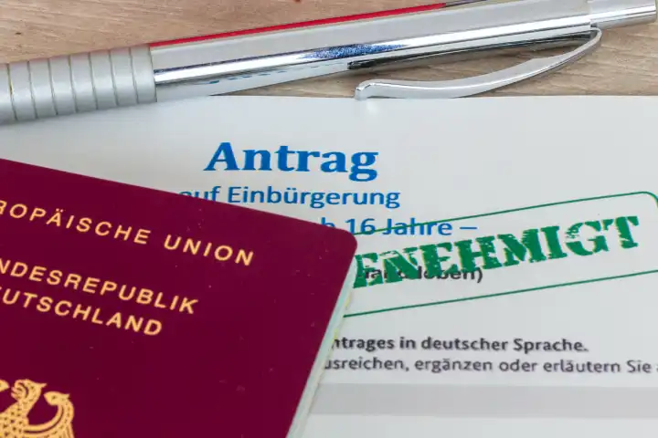 Nahaufnahme von einem Antrag auf Einbürgerung in die Bundesrepublik Deutschland mit symbolischen Stempel GENEHMIGT