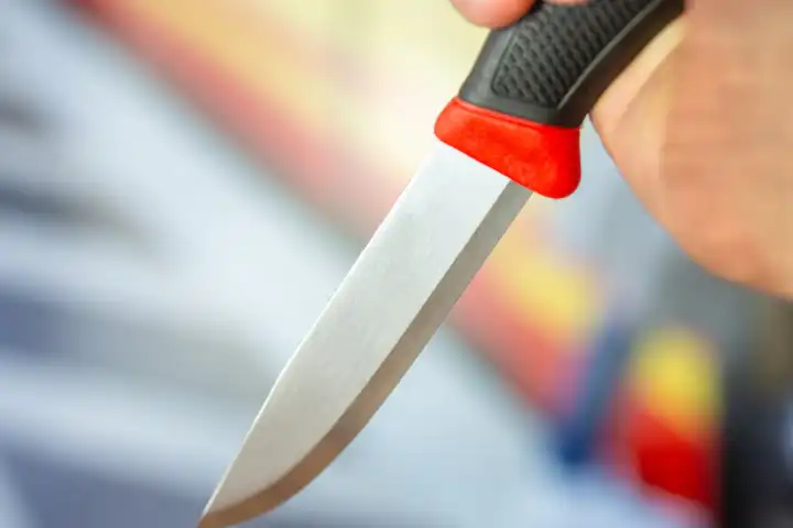 Symbolbild Messerattacke: Nahaufnahme von einem Messer in der Hand eines Mannes