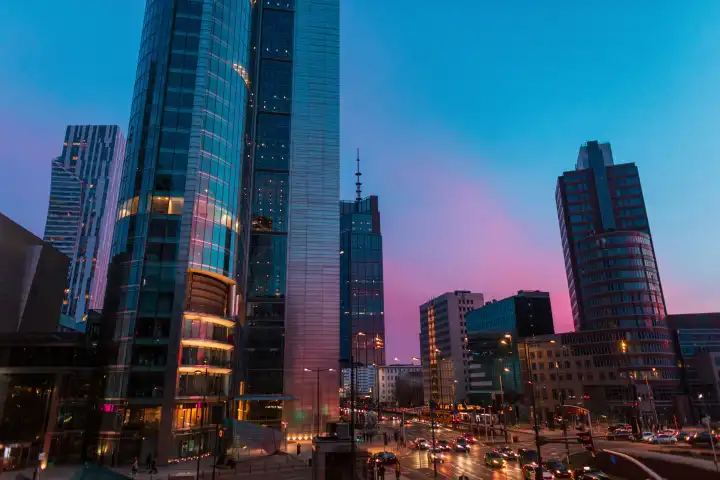 Beautiful modern city of Warsaw with buildings and road on the evening sunset sky with blue and pink light. Poland 