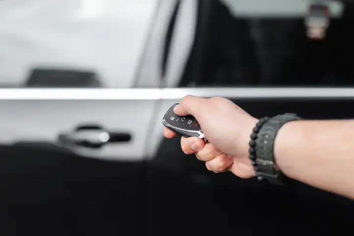 man holds the keys and opens the car. Car rental and test drive