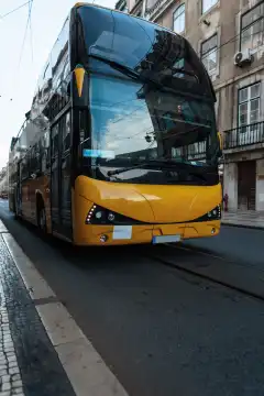 Big yellow bus rides in the city with Lisbon, Portugal. Travel and Holidays
