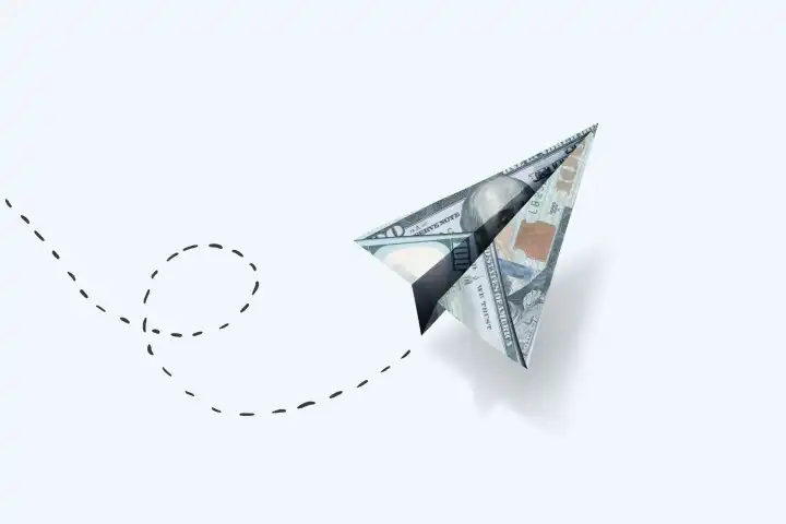 Papier Dollar Flugzeug fliegt auf einem weißen Hintergrund, kreative Idee. Geschäft und Finanzen, Konzept. Erfolgreicher Start-up