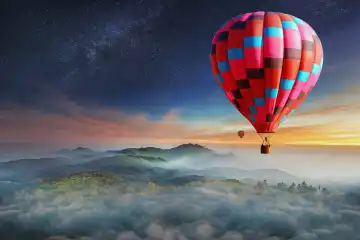 Bunte Heißluftballons fliegen über den Berg mit mit Sternen. Schöne Berge Landschaft mit Wolken bei Sonnenuntergang