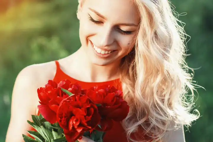 Close-up portrait of fashion beautiful smiling woman with red flowers.